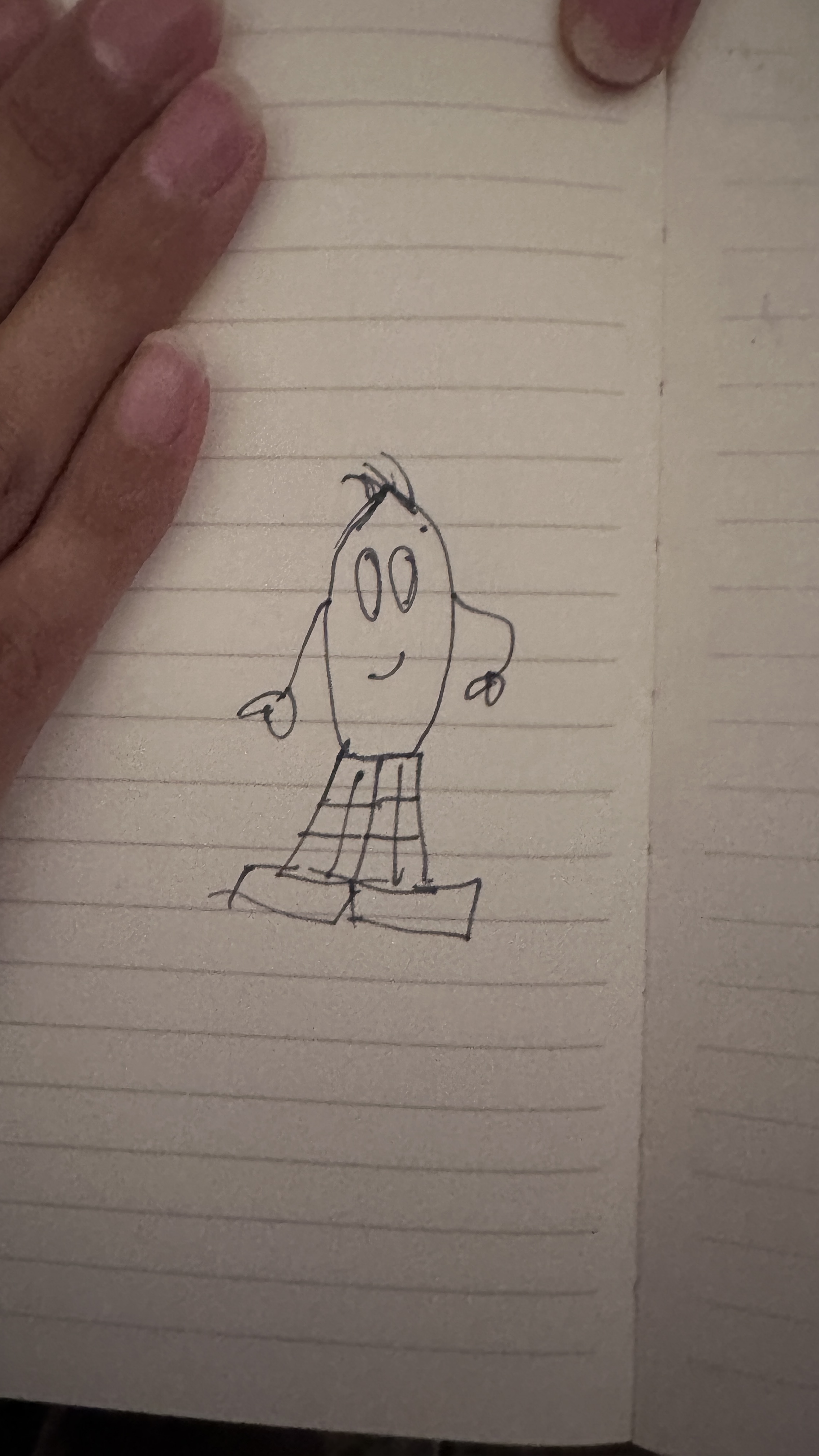 The original hand-drawn NIBS character on lined notebook paper, with oval eyes, a tuft of hair and checked trousers